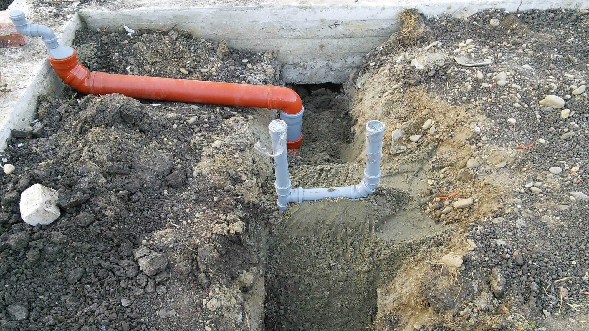 Водопроводные и канализационные трубы зарывают. Изгиб для 110 трубы канализации. Гильза для канализационных труб 110 в ленточном фундаменте. Глубина закладывания канализационных труб. Прокладка канализации в фундаменте.